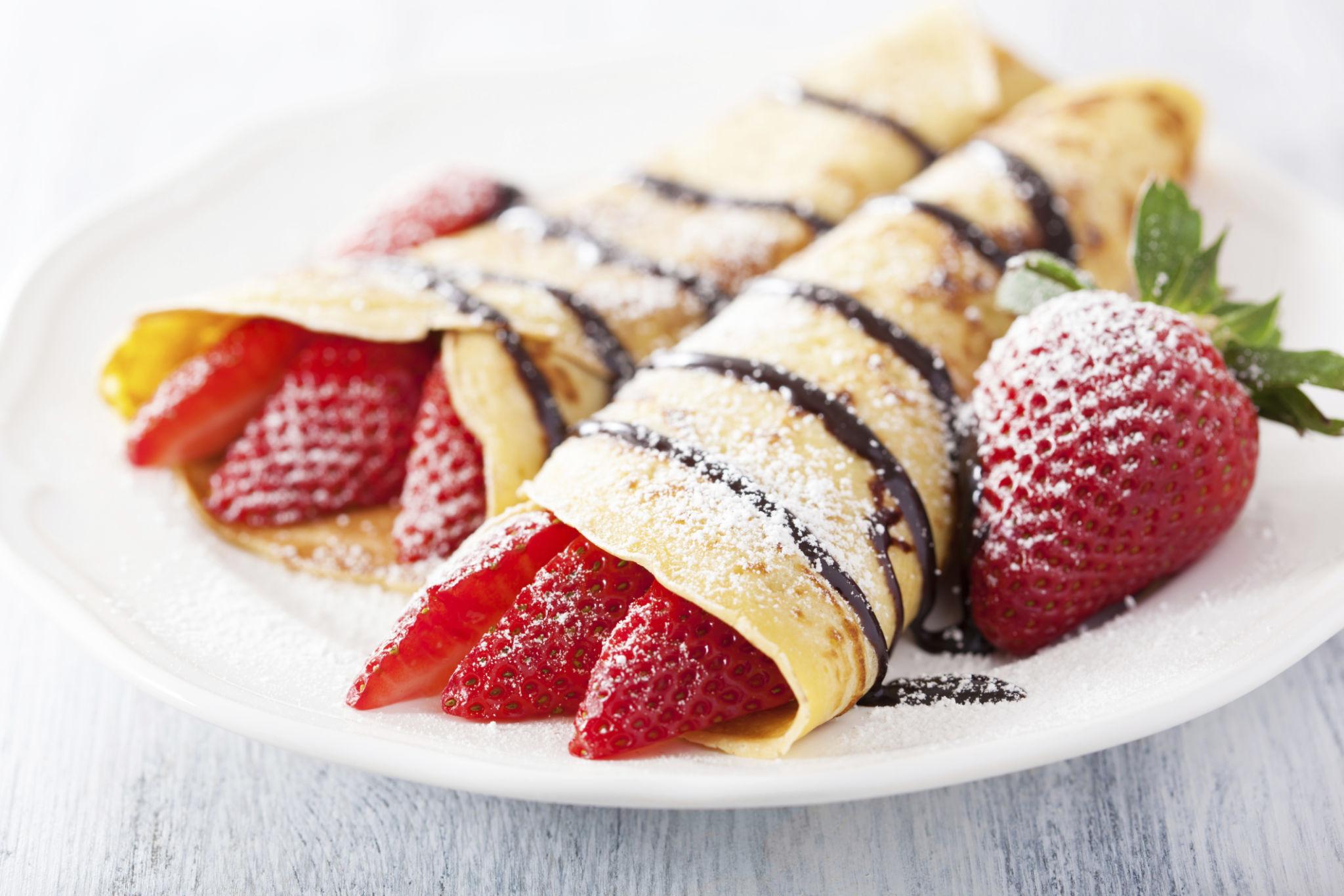 Crêpes met aardbeien, chocoladesaus en poedersuiker